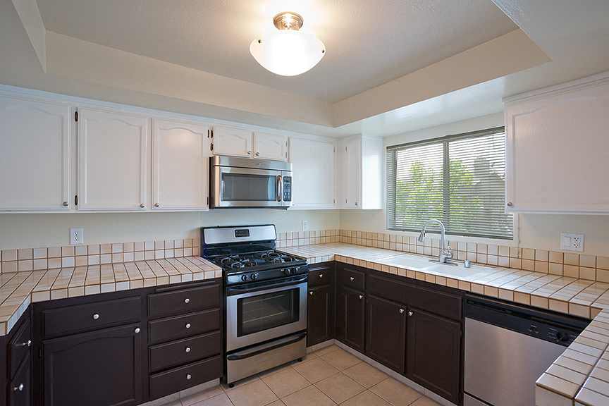 a kitchen with a stove and a sink and a microwave